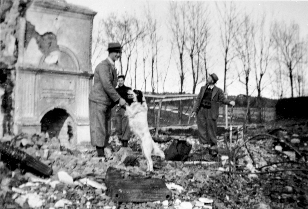 Anno Domkirkeodden, Inspeksjon av branntomta på Hovinsholm, Helgøya etter storbrannen den 20.12.1937. Gartner Kjølås til høyre og Georg Ørbekk med hunden som varslet brannen.