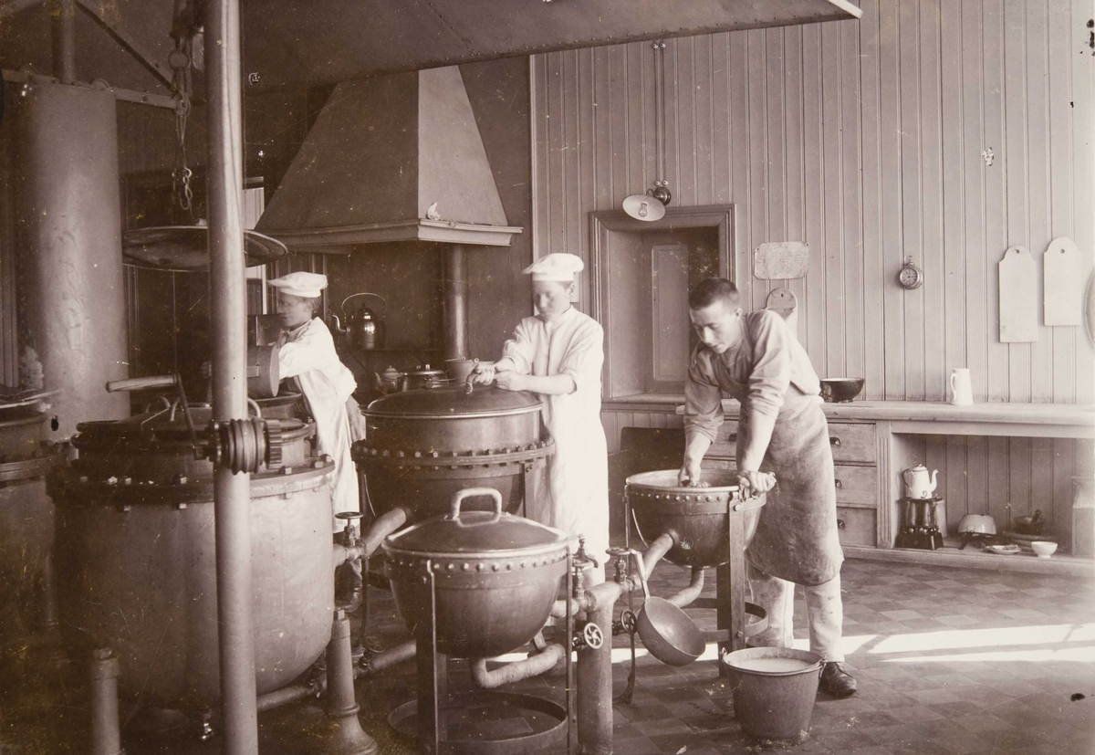 Berg & Høeg, Fra kjøkkenet på Bastøy skolehjem, Bastøya, ca. 1903. Tre elever har kjøkkentjeneste.