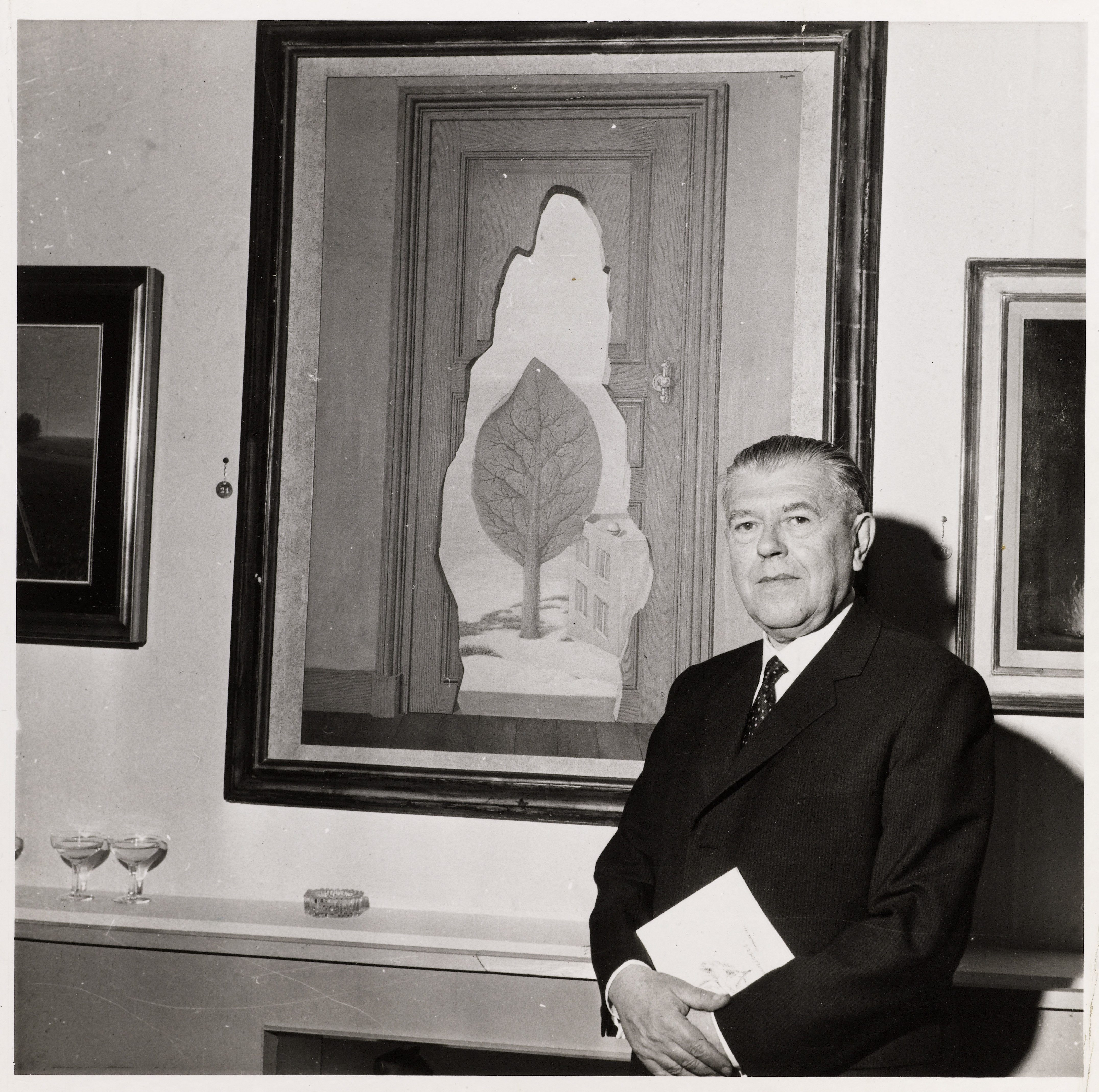 Anonyme, Portrait en buste du peintre surréaliste René Magritte (1898-1967) le 18 octobre 1961 devant une de ses toiles "La perspective amoureuse" de 1935
