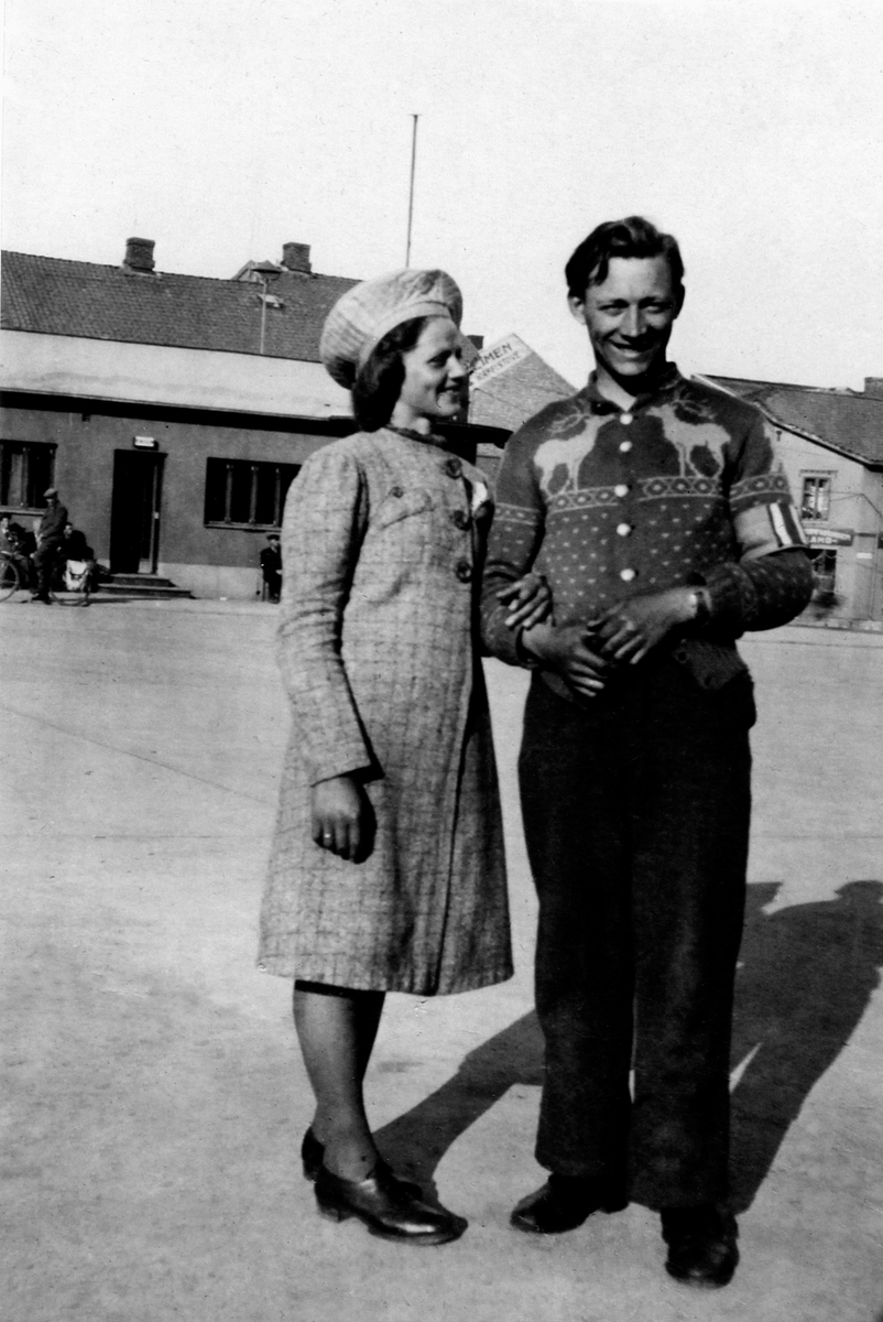 Anno Domkirkeodden, ØSTRE TORG. FRIIGJØRINGSDAGENE. FRA VENSTRE NYFORLOVEDE INGA TINGSTADBERGET OG JARLE LØKENHAGEN MED HJEMMEFRONTSBIND PÅ VENSTRE ARM. BILDET ER TROLIG TATT 12. MAI 1945