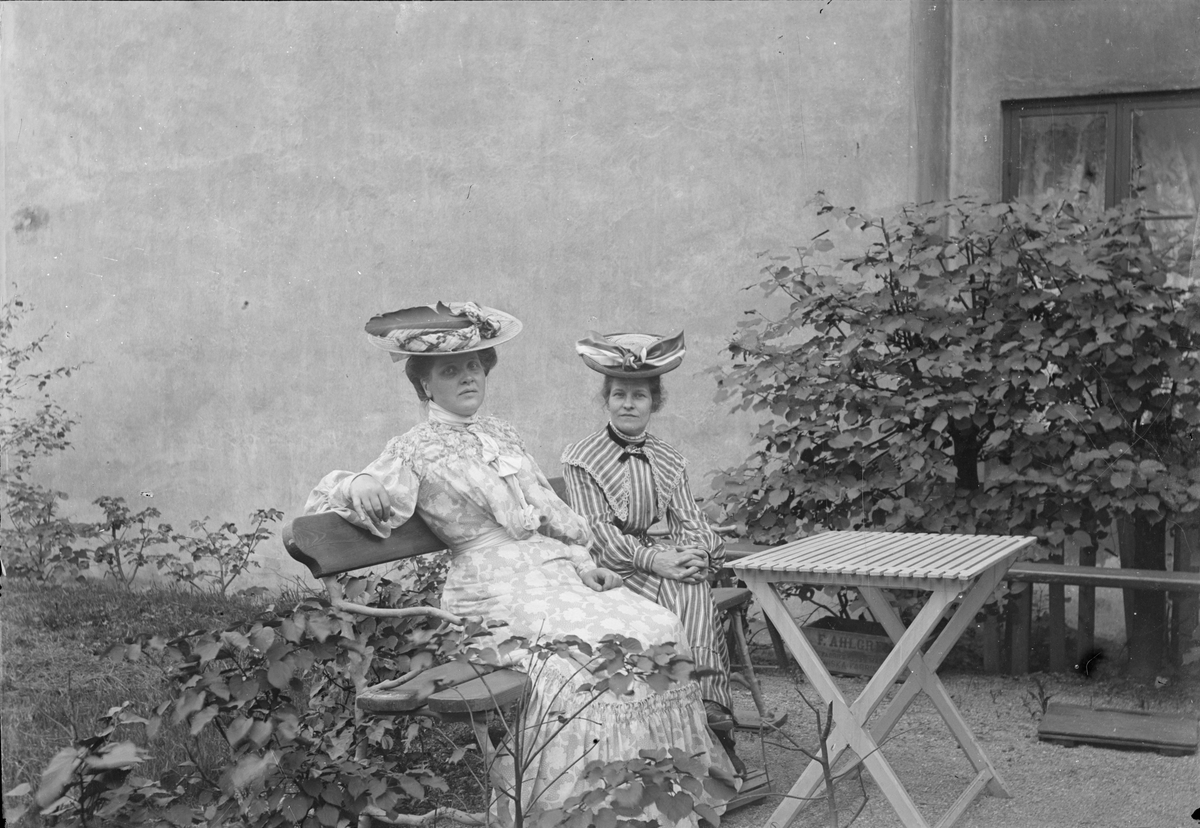 Henri Osti's Fotografiateliér, Emma Osti och kvinna i trädgården, Bredgränd 11, Uppsala 1895