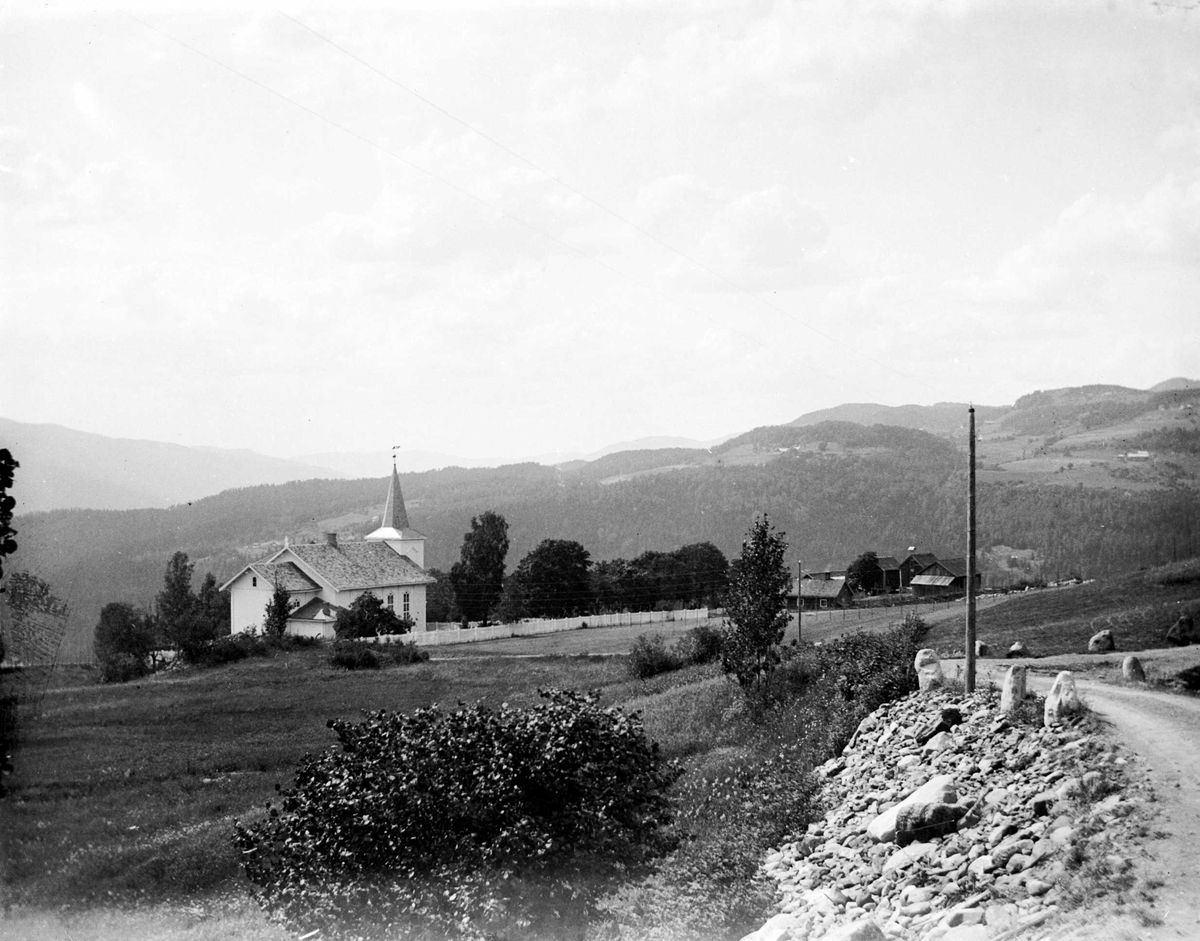 Juliane Fredrikke Langberg, Hurum kirke med utsyn over landskapet omkring. Veistykke med stabbesteiner t.h.. Fra malerinne Juliane Fredrikke Langbergs (1856-1930) samling, tatt ca.1895-1910 med motivkrets slekt og venner samt steder tilknyttet samvær med disse.