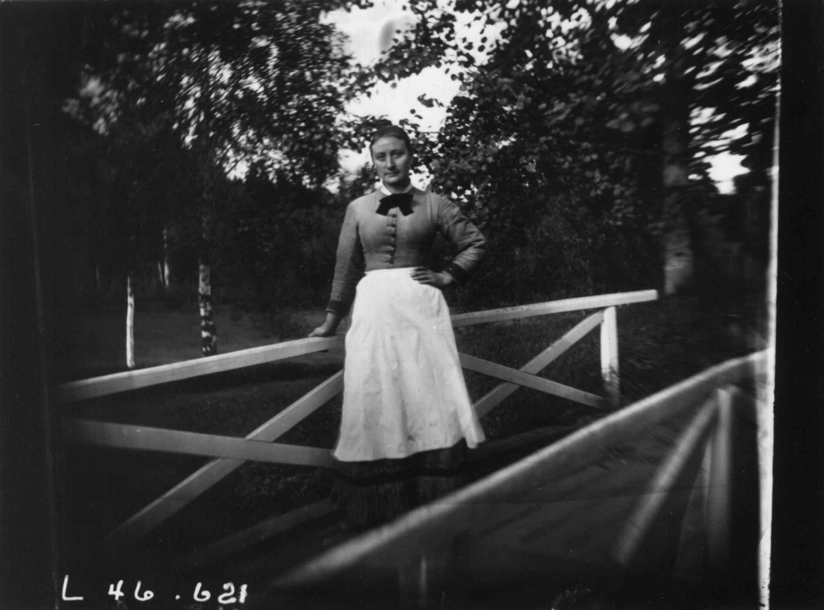 Fredrik Emil Faye, Portrett, ukjent kvinne på bro. Fra portrettserie av personer som bodde på eller besøkte Dal gård, Ullensaker, fotografert av gårdens eier, kammerherre Fredrik Emil Faye (1844-1903) i årene 1875-1900.