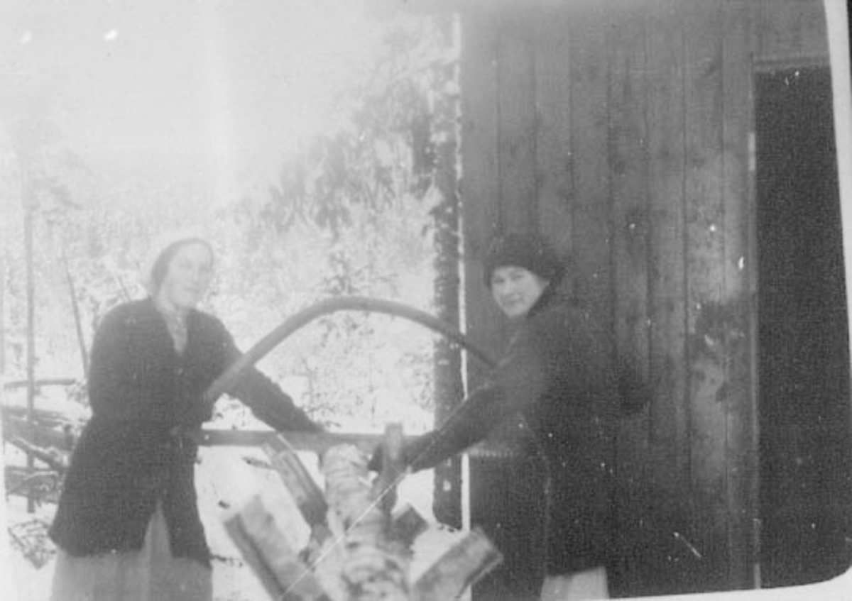 Normann Helger, 2 DAMER SAGER VED MED SAG AV GAMMEL TYPE, TENNARBUE, VINTER, TIL HØYRE: ANNA STENSBY