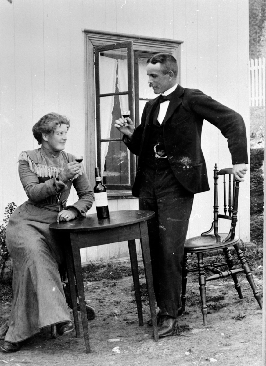 Anno Domkirkeodden, Anna Godager forlover seg med Ole Pedersen Røste, Venningrud, Helgøya. De giftet seg i 1905. Bord med vinflaske. Bildet er trolig fra Godager/Guåker på Nes.