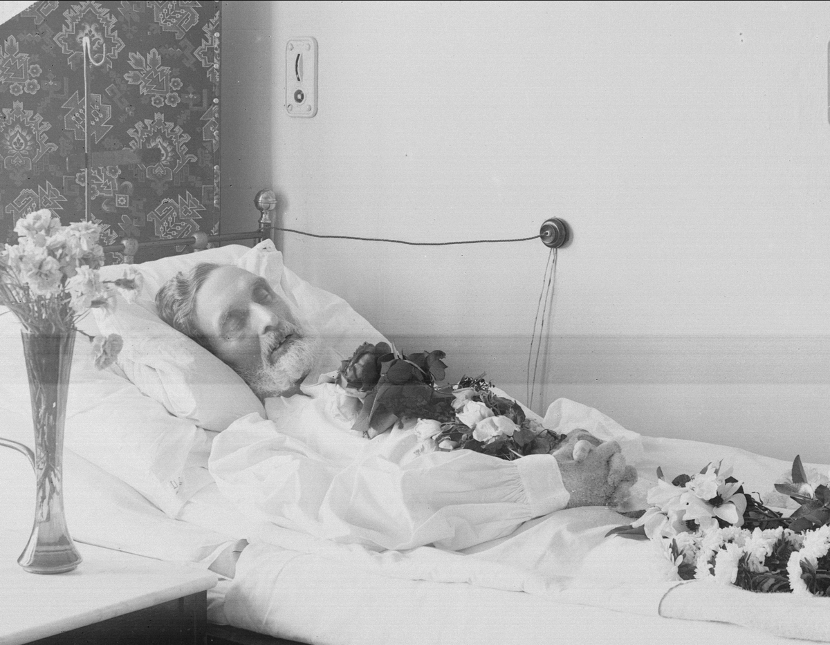 Gustav Borgen, Post mortem-fotografi. Død mann i pyntet seng. Trolig på sykehus.