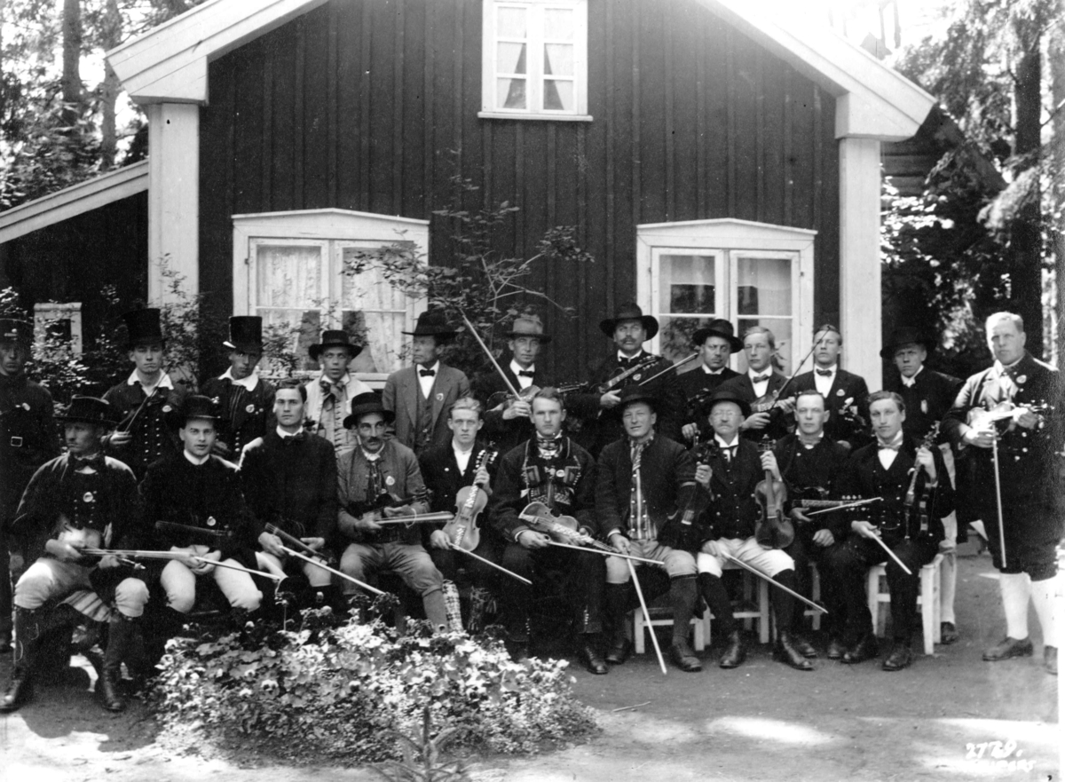 Hermann Christian Neupert, Felespillere. Gruppebilde foran et hus. Noen i bunader, noen i dress.