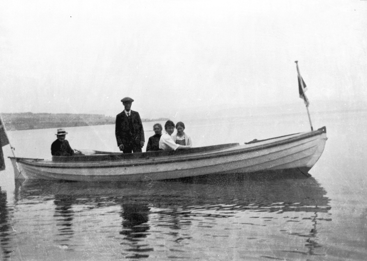 Anno Domkirkeodden, Mororbåt på Mjøsa utenfor Sund, Helgøya. 5 personer i båten. Tåle Knatterud (1845-1930) til venstre, båteier Ivar Sund (1886-1971) stående.