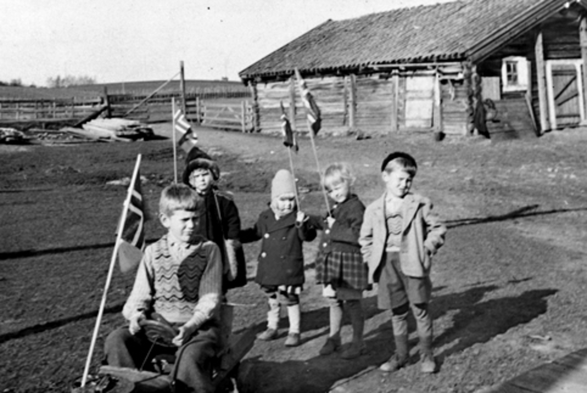 Anno Domkirkeodden, UTHUS GARD I STANGE, BARN, FREDSFEIRING, FRIGJØRINGEN, 2. VERDENSKRIG, ODD KJELL SKJEGSTAD PÅ LEKEBIL OG ANNAR SKJEGSTAD T. H. , 3 UKJENTE JENTER, NORSKE FLAGG, 8-5-1945.