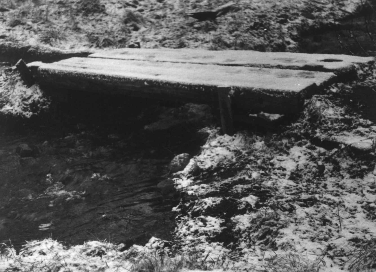 Anna Grostøl, En lite plankebro over en bekk. Rostadal, Målselv 1940-årene.