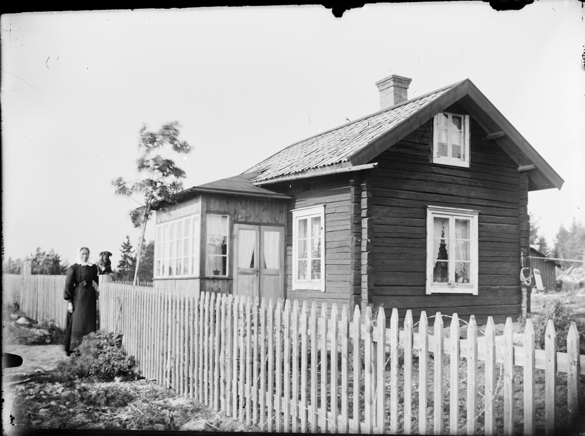 Skötsner-Edhlund, Kvinna och hund utanför bostadshus, Östhammar, Uppland