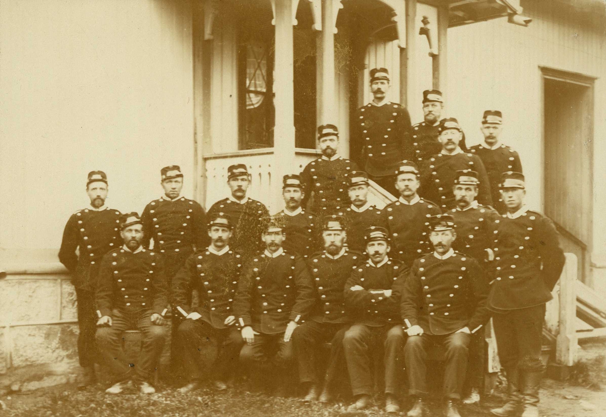 Narve Skarpmoen, Grensevakter, Aremark, Østfold 1905. Gruppe oppstilt for fotografering foran inngangsparti på hus. Carl Amundsen nr. 3 fra venstre, annen rekke.