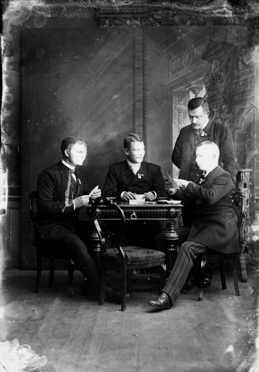 Henri Osti's Fotografiateliér, K E Palmi and three other men play cards, Uppsala 1890