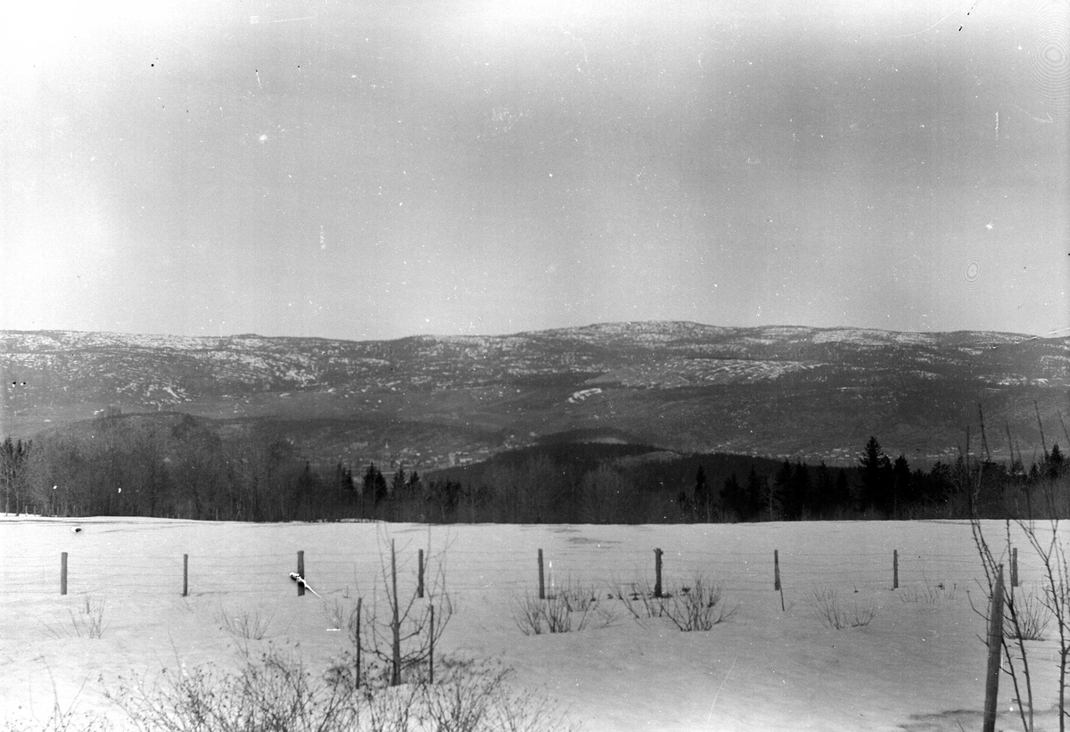 Juliane Fredrikke Langberg, Fra Hurum eller Rakkestad (ant.), utsyn over landlig område med gjerde i forgrunnen. Bebyggelse i dalbunnen i bakgrunnen. Fotografens svoger var sokneprest disse stedene. Fra malerinne Juliane Fredrikke Langbergs (1856-1930) samling, tatt ca.1895-1910 med motivkrets slekt og venner samt steder tilk…