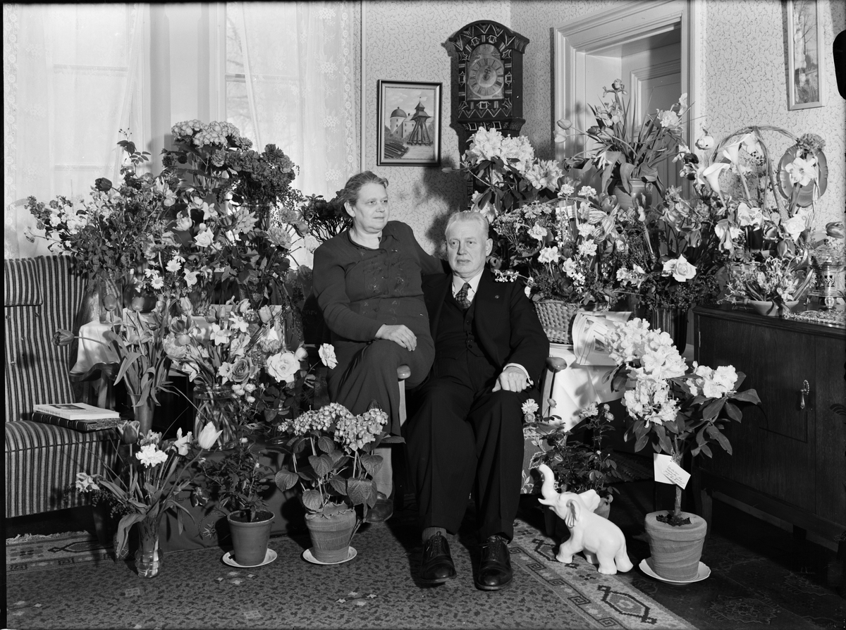 Paul Sandberg, Kvinna och man i hemmiljö omgiven av blommor, Uppland 1950