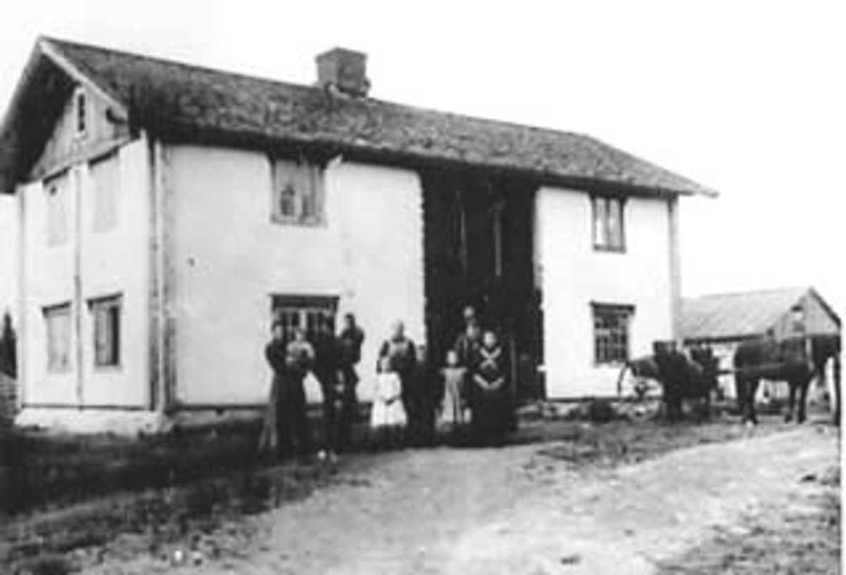 Anno Domkirkeodden, EKSTERIØR: GARDSBRUK, SVENDBY (korrigert til Brunstad), HOVEDBYGNINGEN, GRUPPE: 11 FORAN, FRA VENSTRE: ANNA SVENDY MED PERNILLE, JOHAN MED ASBJØRN, JOHAN, ASTRID, ANNA OLSTAD, GUTT: SYVER, SIGRID, EMMA, KRISTIAN NODLI, ÅSBYGDA