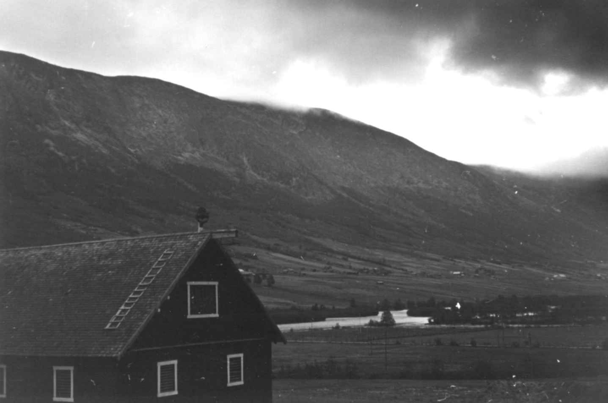 Anna Grostøl, Skjåk, Oppland 1941. Oversiktsbilde med en bygning i forgrunnen.