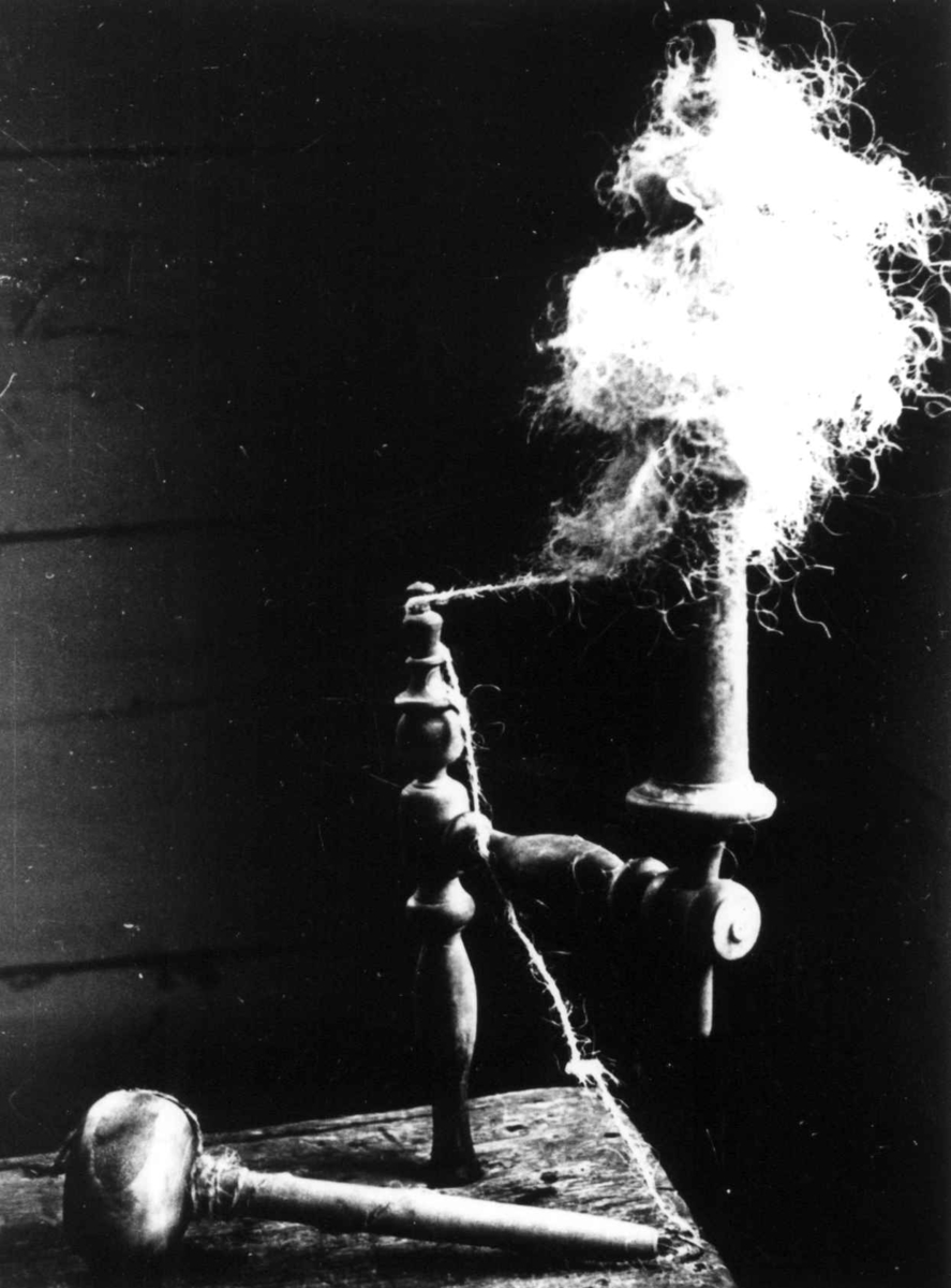 Anna Grostøl, Ragnhild Åvitsland spinner kutagl og grov ull på en liten hjemmelaget håndrokk i tre. Eiken, Hægebostad, Vest-Agder 1941.