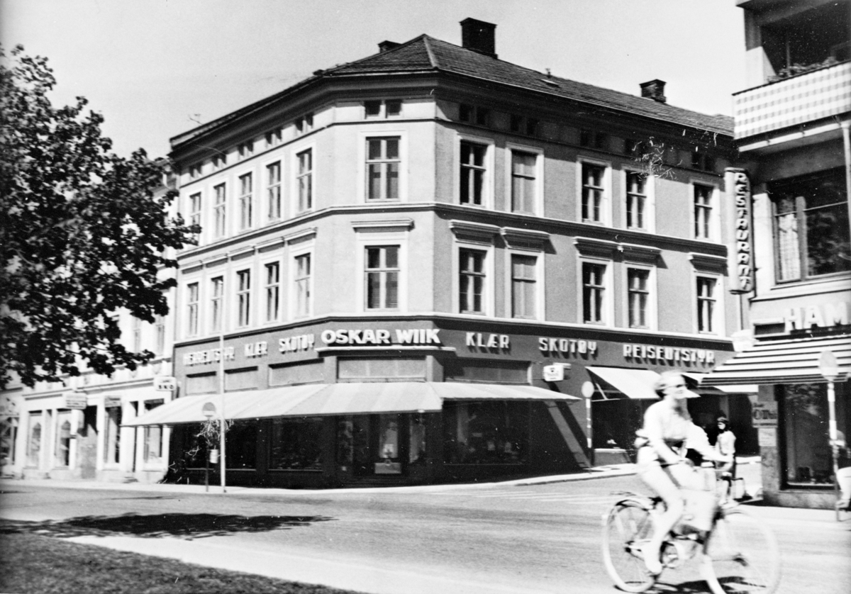 Anno Domkirkeodden, EKSTERIØR STRANDGATA 51 MED OSKAR WIIKS FORRETNING I FORGRUNNEN DAME PÅ SYKKEL