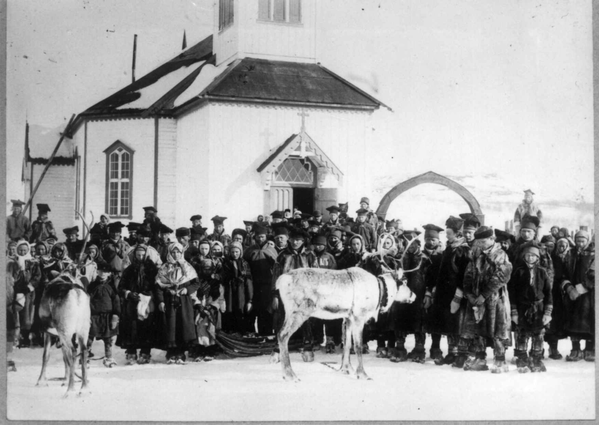 Ellisif Rannveig Wessel, Samer foran inngangspartiet etter gudstjeneste i Sør-Varanger kirke, 456, Kirkenes, Sør-Varanger, Finnmark, før 1900. Ved kirkedøra står presten Emil Stang Lund med hvit krave.