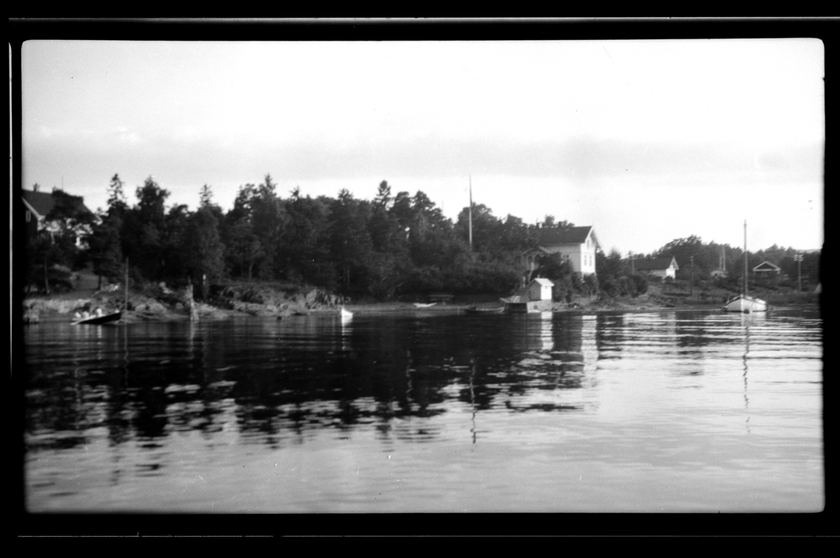 Rolf Sr. Sundt, Flere hus og båter langs stranden ved ant. Konglungen. Fotografert 1930.