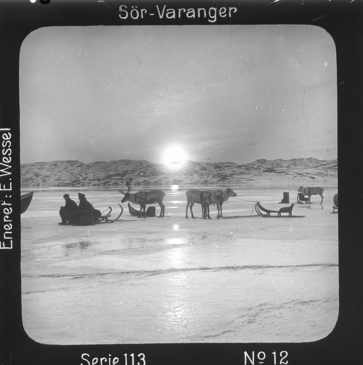 Ellisif Rannveig Wessel, Postskip ventes i midnattsol i midten av mai ved iskanten utenfor Kirkenes, Sør-Varanger, Finnmark. Ventende samer med rein og pulker. Motivet har nr.12 i lysbildeforedraget kalt "I lappernes land - Sør-Varanger", utgitt i Nerliens Lysbilledserier, serie nr 113.