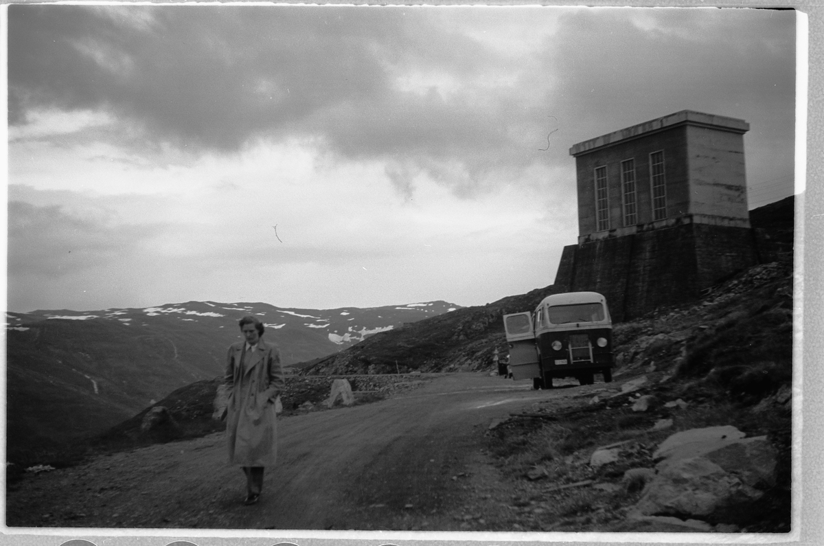 Håkon Prestkværn, Ukjent kvinne på en vei med en buss i bakgrunnen. Trolig BUSS D-2968 STUDEBAKER 1935-36, sml.
