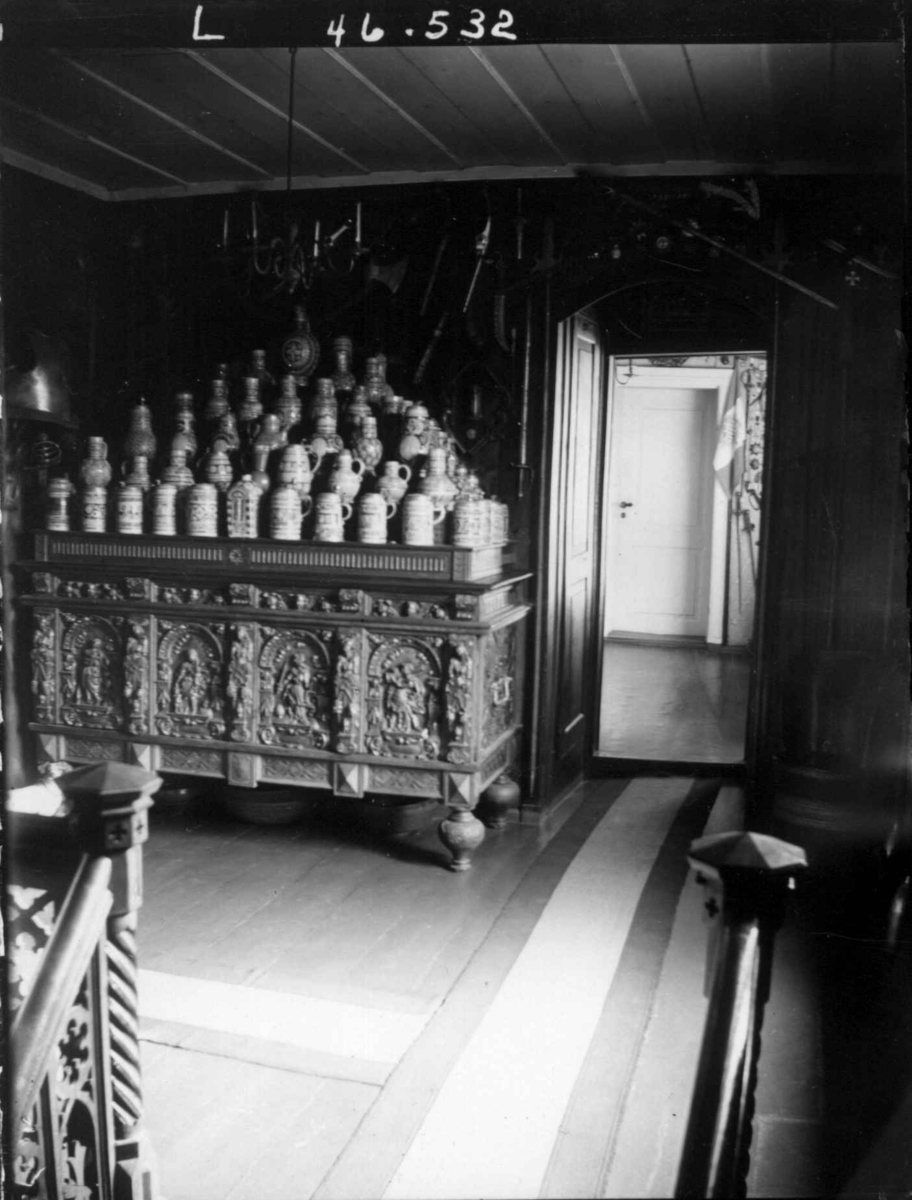Fredrik Emil Faye, Interiør, Dal gård, Ullensaker. Oppgangen med kiste med oppstablede krus. Fra serie fotografert av kammerherre Fredrik Emil Faye (1844-1903), gårdens eier.