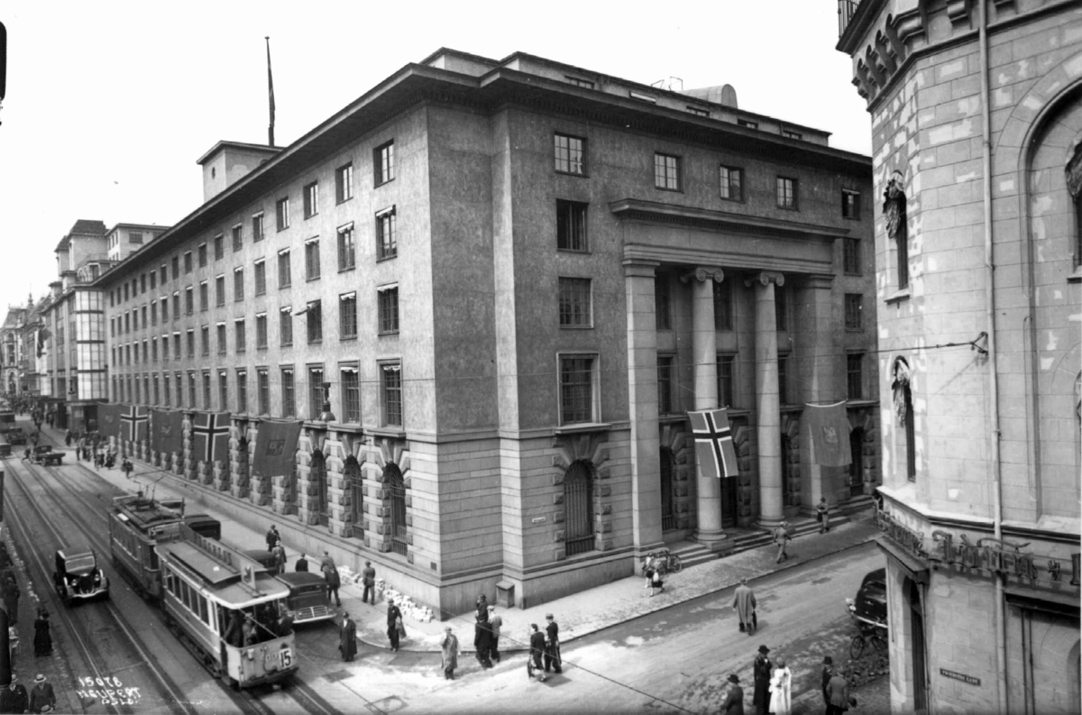 Hermann Christian Neupert, Den Norske Creditbank, Kirkegata 21, Oslo. 1936. Gatebilde med trafikk og bygningen. Trikk, biler og fotgjengere.