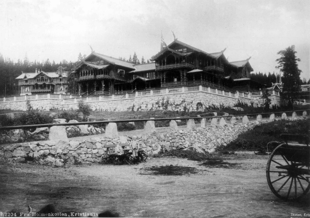 Marthinius Skøien, Holmenkollen turisthotell. Oslo. Hotellet sett fra nedsiden. Barn på benk i forgrunnen.