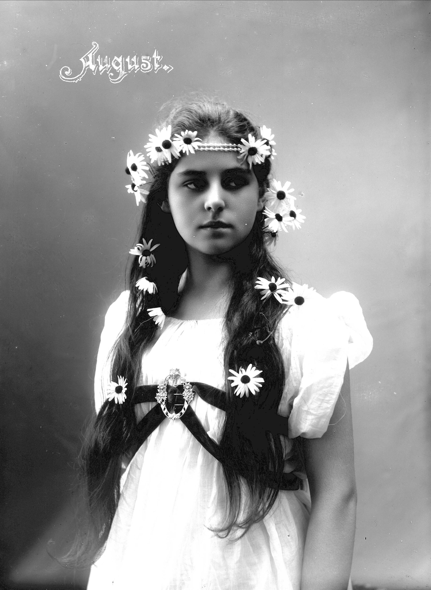 Solveig Lund, Studioportrett av kvinne i drakt med blomster og smykke i håret.