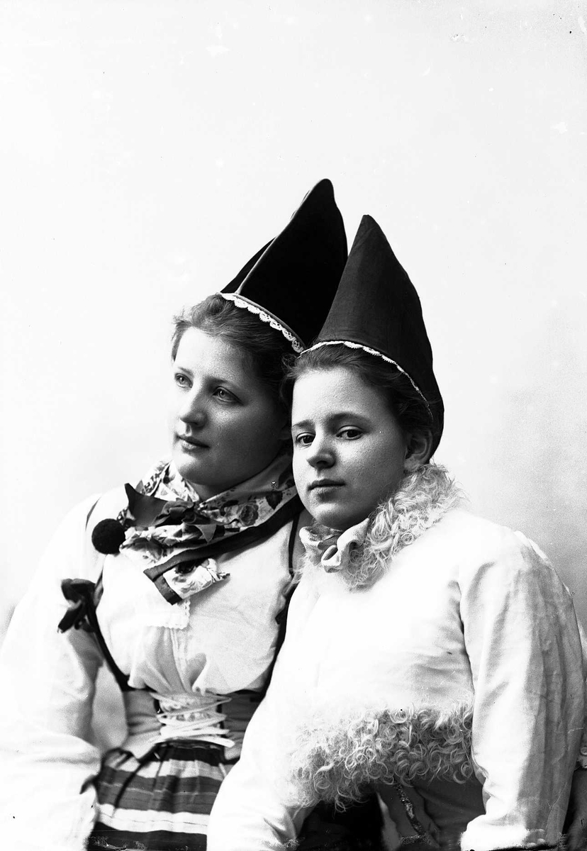Solveig Lund, To kvinner i drakt og lue.