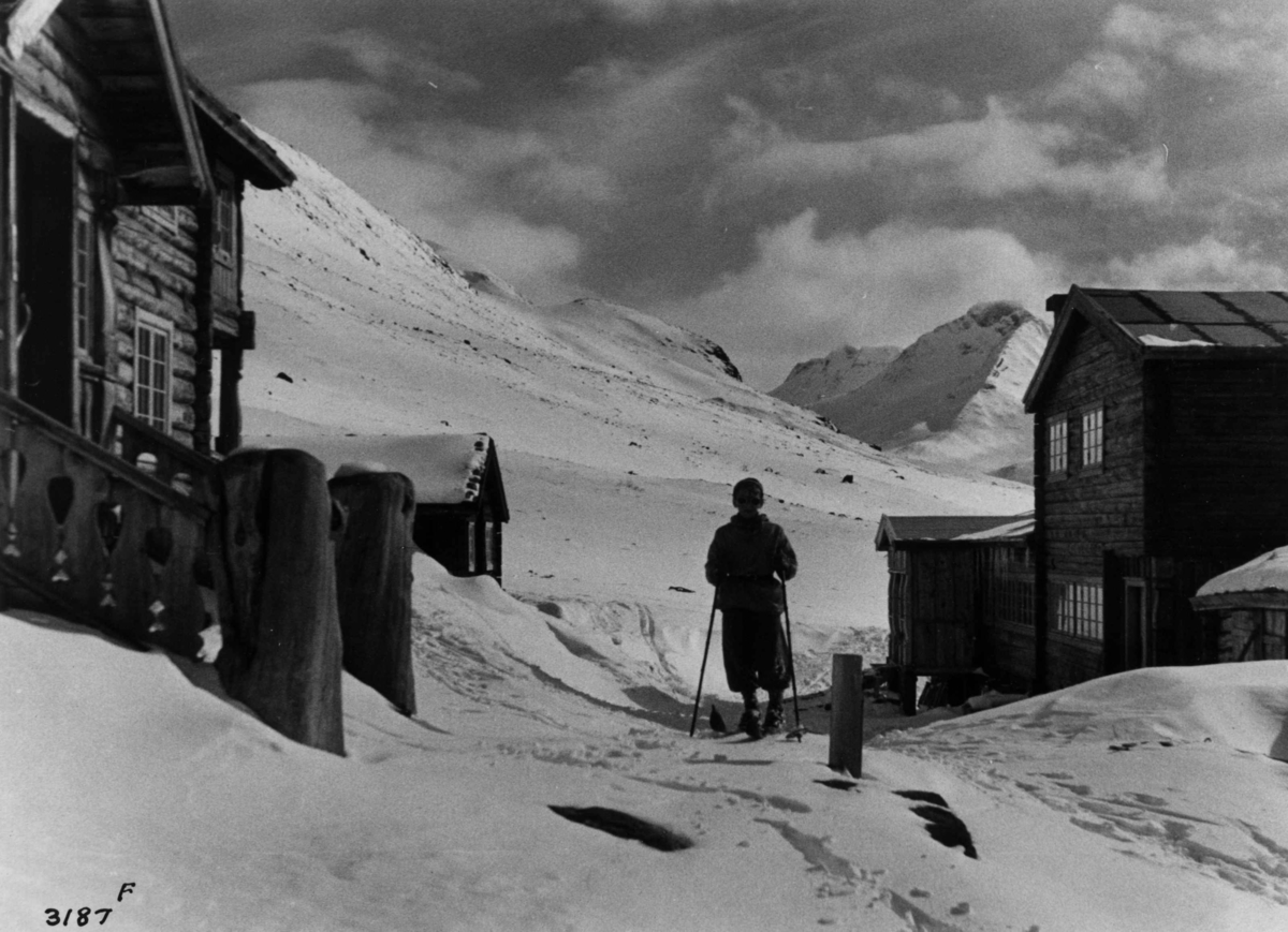 Anders Beer Wilse, Skiløper ved Spiterstulen i Visdalen i Jotunheimen med snødekte fjell.