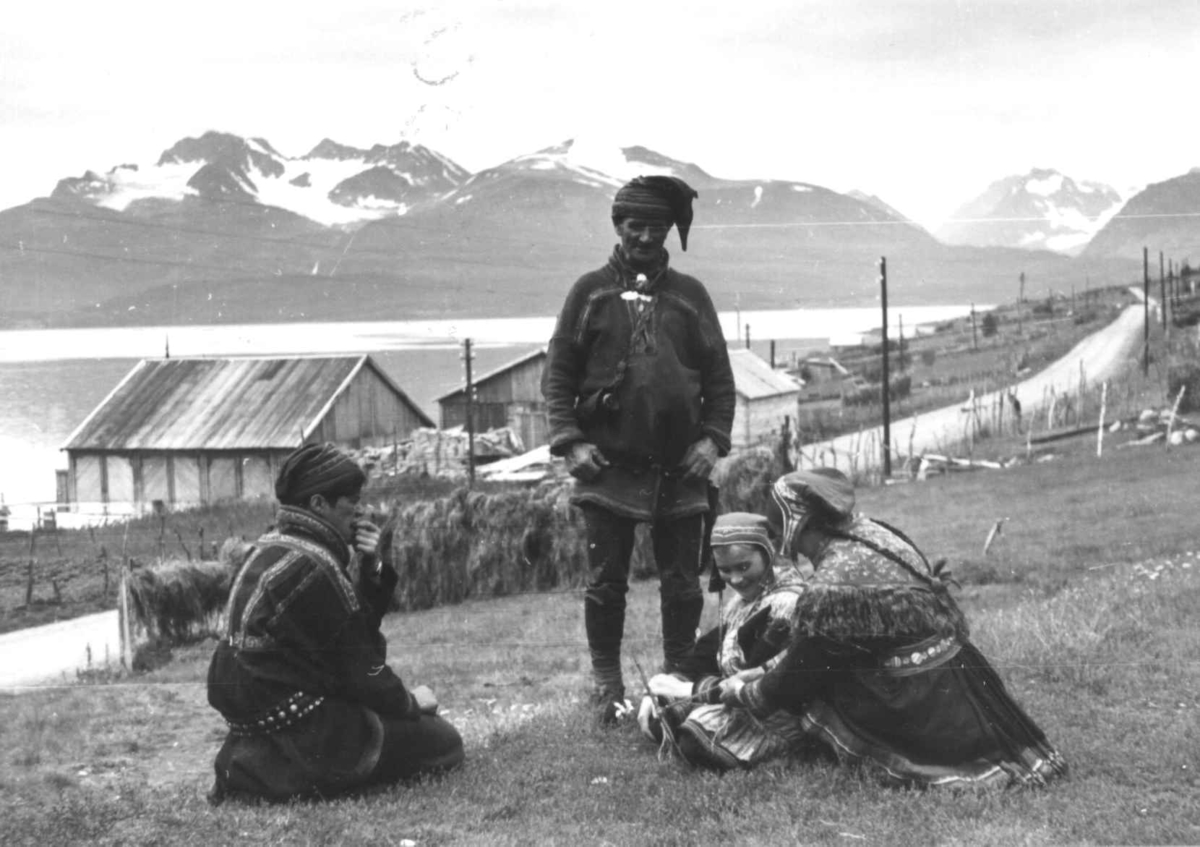 Anna Grostøl, To kvinner fletter bånd, to menn ser på. Olderdalen, Kåfjord, Troms 1947.