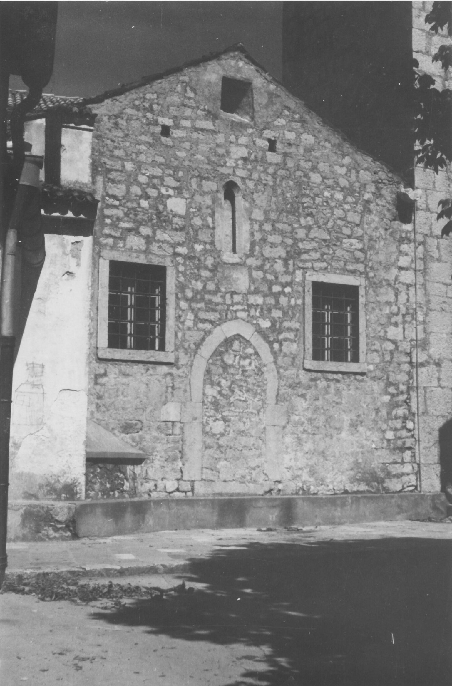 Branko Fučić, Omišalj, župna crkva Uznesenja Blažene Djevice Marije, vanjština: pogled na sadašnju sakristiju sa zazidanim gotičkim vratima, uz zvonik