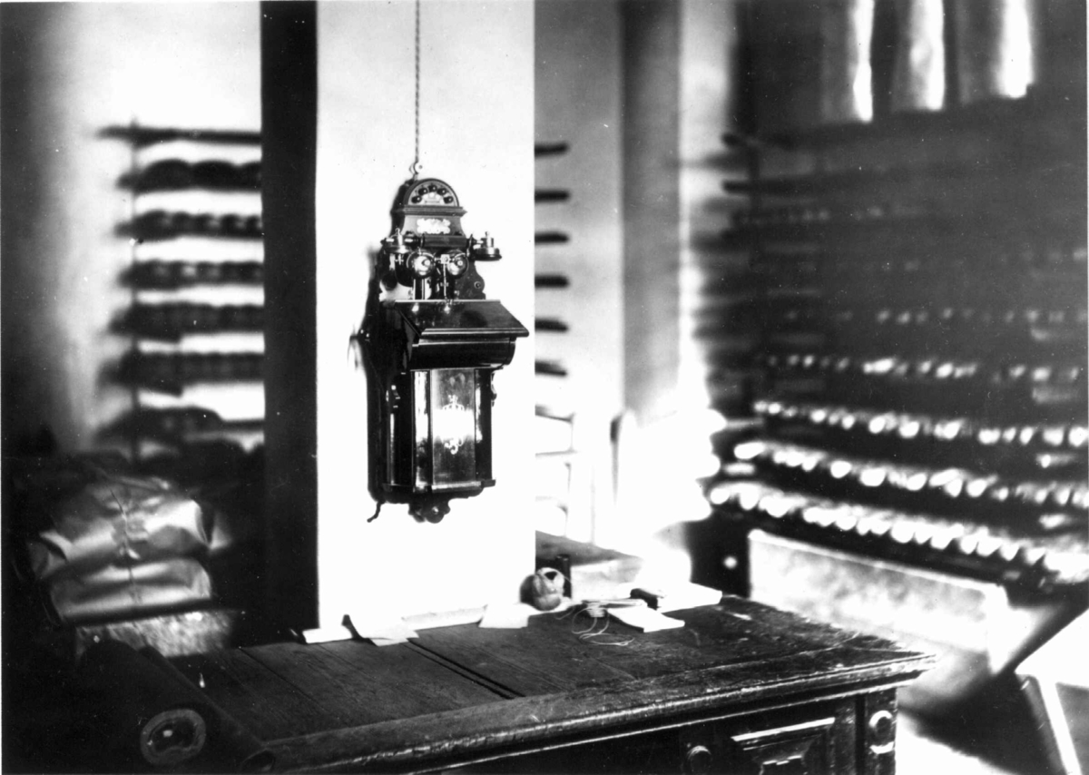 Narve Skarpmoen, A. Hansens Bakeri, Universitetsgata 8, Oslo, ca. 1910. Interiør fra lager med telefon, arbeidsbenk og brød i hyller.