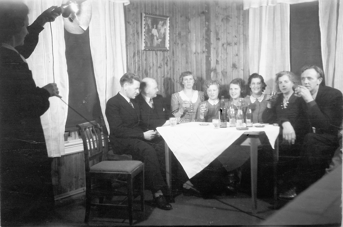 Håkon Prestkværn, Interiør, stue. Ukjent familiegruppe samlet rundt et bord.