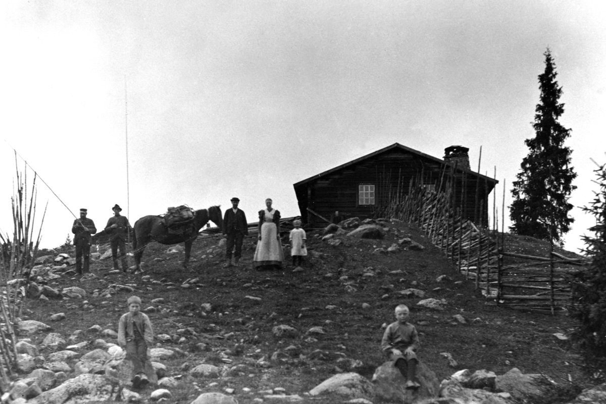 Anno Domkirkeodden, Gruppe voksne og barn med kløvhest ved størhuset på Bergsbu seter. Ringsaker Almenning. Sommeren 1900 brant hele seteranlegget på Bergsbu med flere hus ned til grunnen.