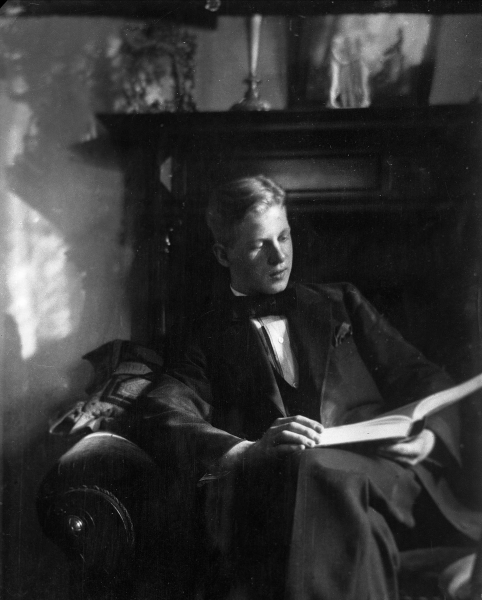 Gustav Borgen, Avfotografering, portrett, ung mann sitter i stolen og leser i en bok