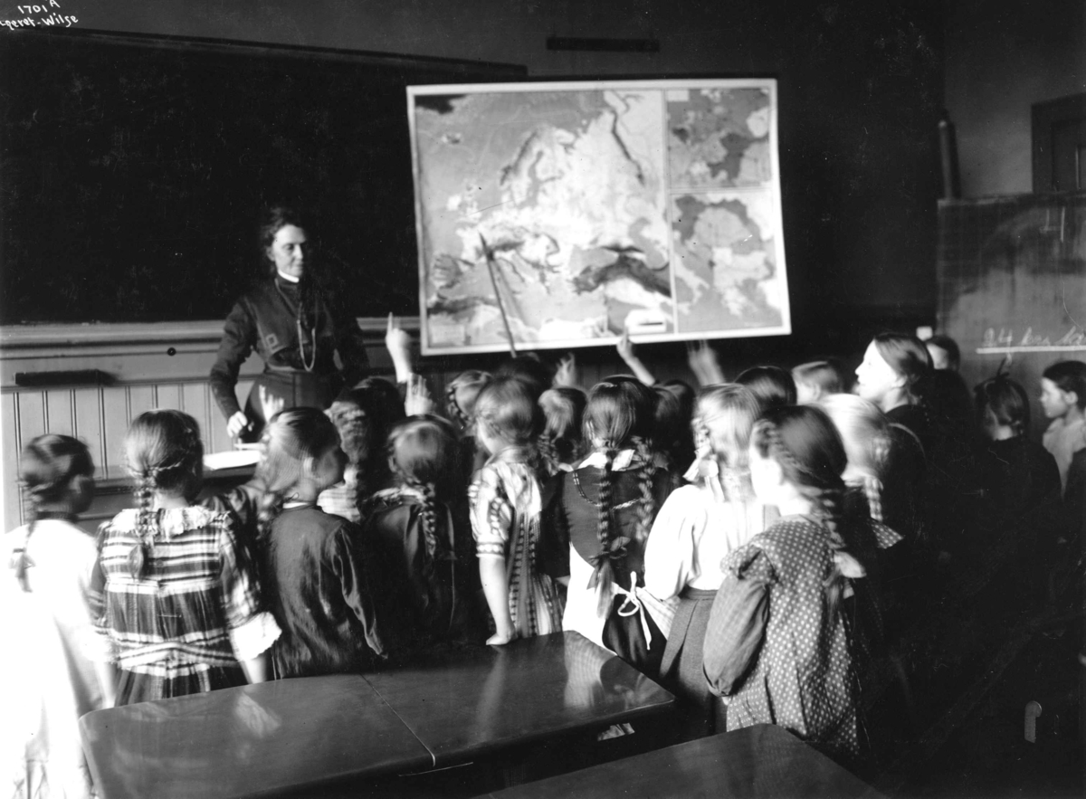 Anders Beer Wilse, Lærerinne Anna Rogstad underviser pikeklasse på Sagene skole. Geografitime med kart.