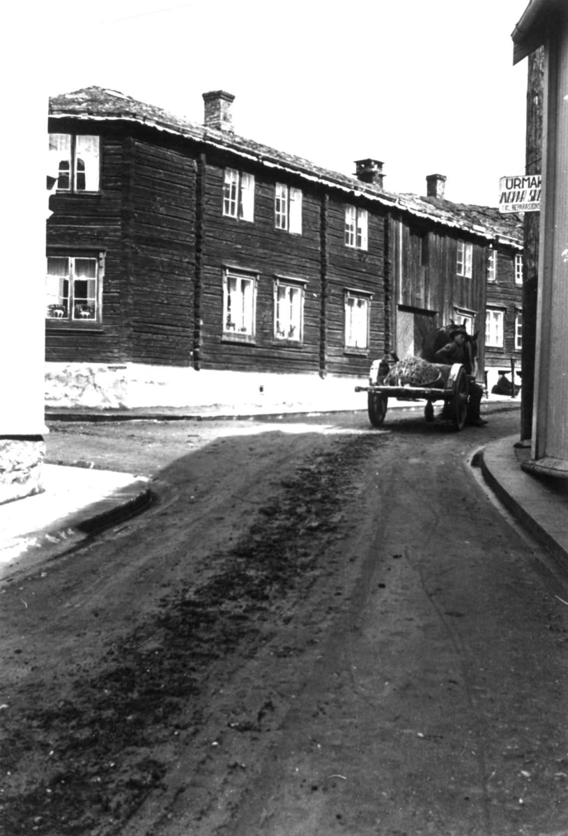 Anna Grostøl, Gatebilde med bygninger og en mann med kjerre, 7. juni 1939.