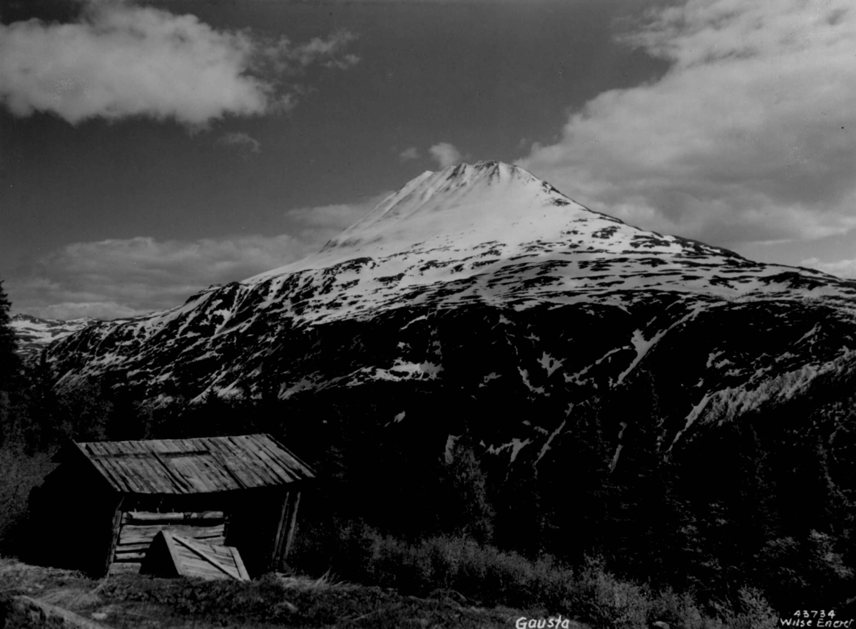 Anders Beer Wilse, Gaustatoppen med falleferdig bygning i forgrunnen. Snødekt fjell.