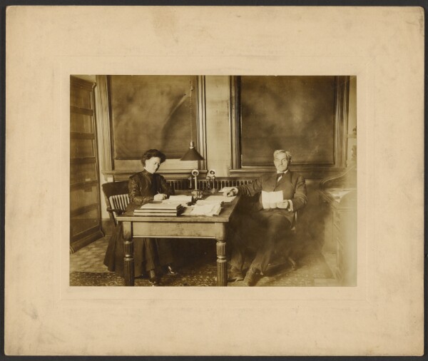 Unknown, [Man and woman sitting at desk]