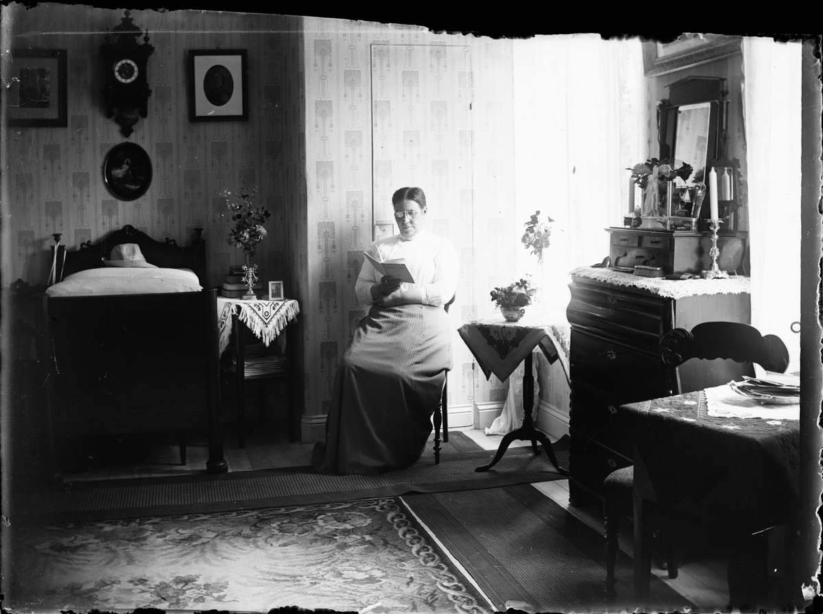 Skötsner-Edhlund, Maria Lindberg sitter vid fönstret och läser en bok, Östhammar, Uppland