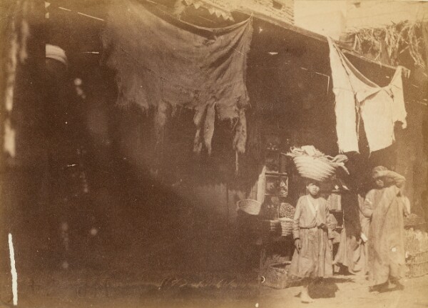 Unknown, [Figures in front of booth]