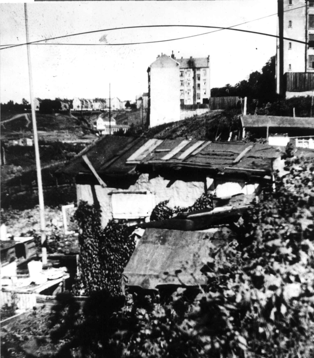 Nanna Broch, Hytter eller skur med murgårder i bakgrunnen, Oslo. Fra boliginspektør Nanna Brochs boligundersøkelser i Oslo 1920-årene.