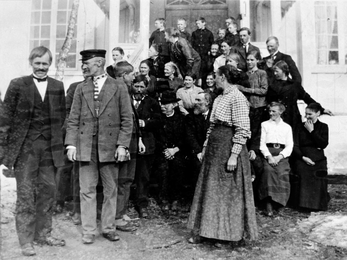Anno Domkirkeodden, Stor gruppe mennesker samlet i anledning Johan Engebretsen Engeland (1839-1934) sin 80 års-dag. Hovinsholm, Helgøya. Frantz Raknerud, Gustav Antonsen, Laura Bakke, Ivar Hagen, Mads Nordstøen, Magda Raknerud, Johan Engebretsen Engeland, Marte Marie Nordstøen, Peder Magnussen Hagen, Tilla Madsen, Tea…