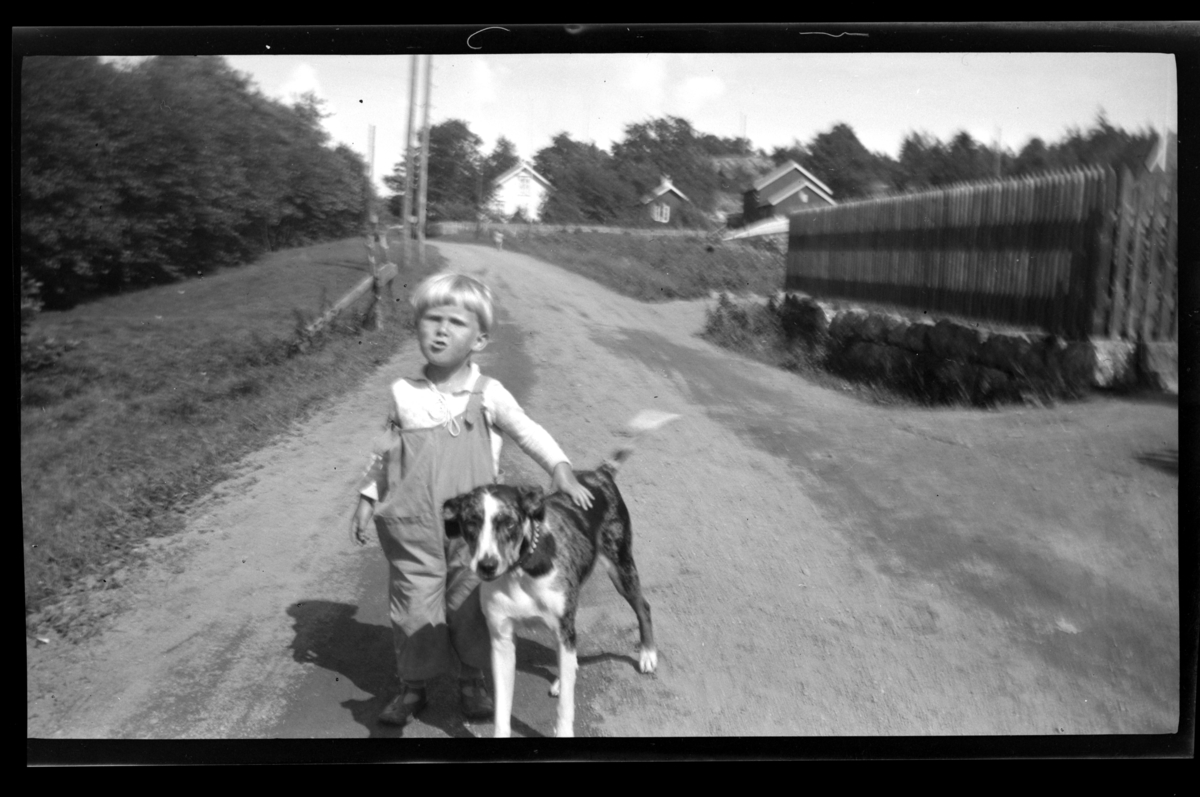Rolf Sr. Sundt, Lars Peter med hund på grusvei på Ula, Vestfold. Fotografert 1932.
