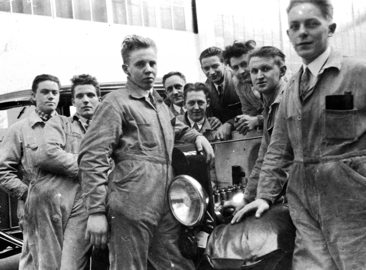 Anno Domkirkeodden, Gruppe menn i kjeledress rundt bil. Bilmekanikere på kurs. Johannes Haug (1909-1986) fra Nes BIlverksted.