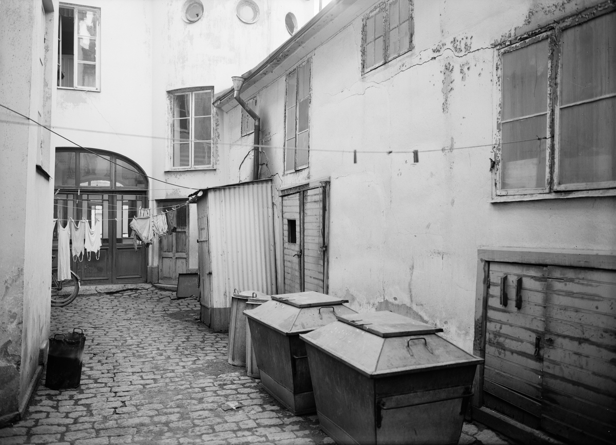 Paul Sandberg, Gårdsinteriör med soptunnor och tvätt på tork, Uppsala 1944